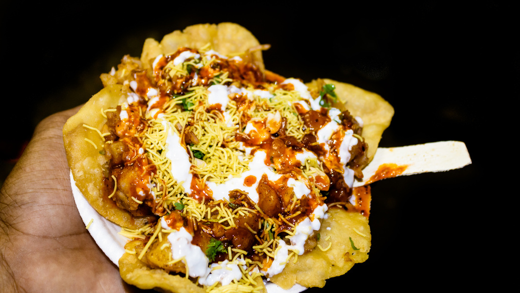 Indian famous Papdi Chaat (Papri Chaat). A yummy snack assorted with crunchy base of Papdi (crisp puris) topped with lip-smacking chutneys, veggies and curd.