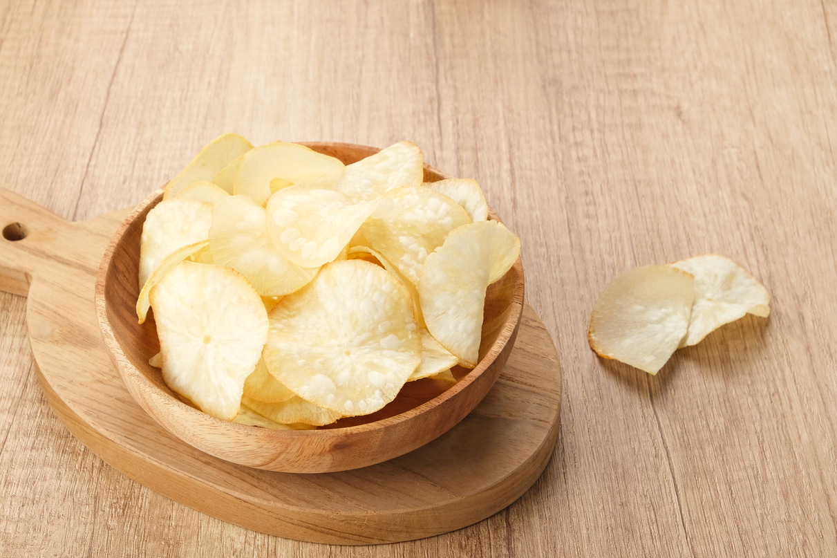 Keripik Singkong or Cassava Chips, Indonesian traditional snack. Served in bowl on wooden background.